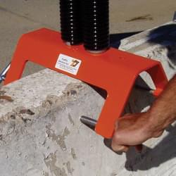 T-Pins with hardened steel points secure stand to concrete barrier wall