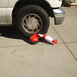 An Enviro-Cone being crushed underneath the tire of a moving vehicle