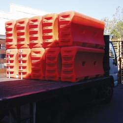 10 TrafFix Water-Cable Barriers stacked 2 high in 5 rows on the back of a flatbed truck